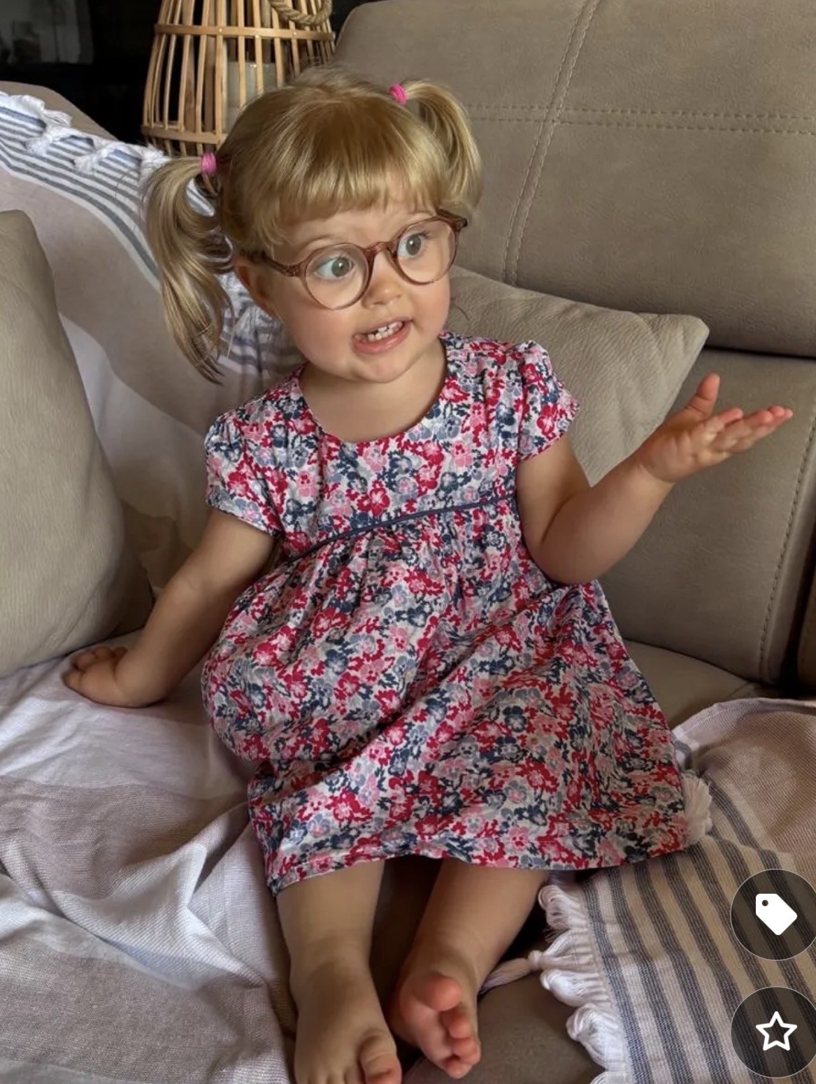 Anna en robe fleurie, assise dans un fauteuil, la main levée comme pour présenter ses arguments.